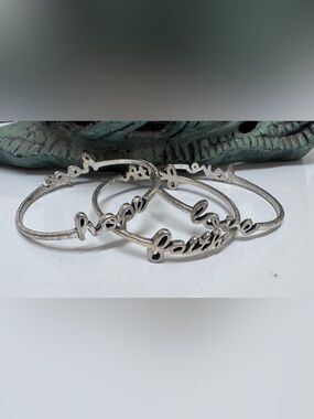 Premier Design Silver bangles feature cursive lettering faith", "hope"and
"love"
